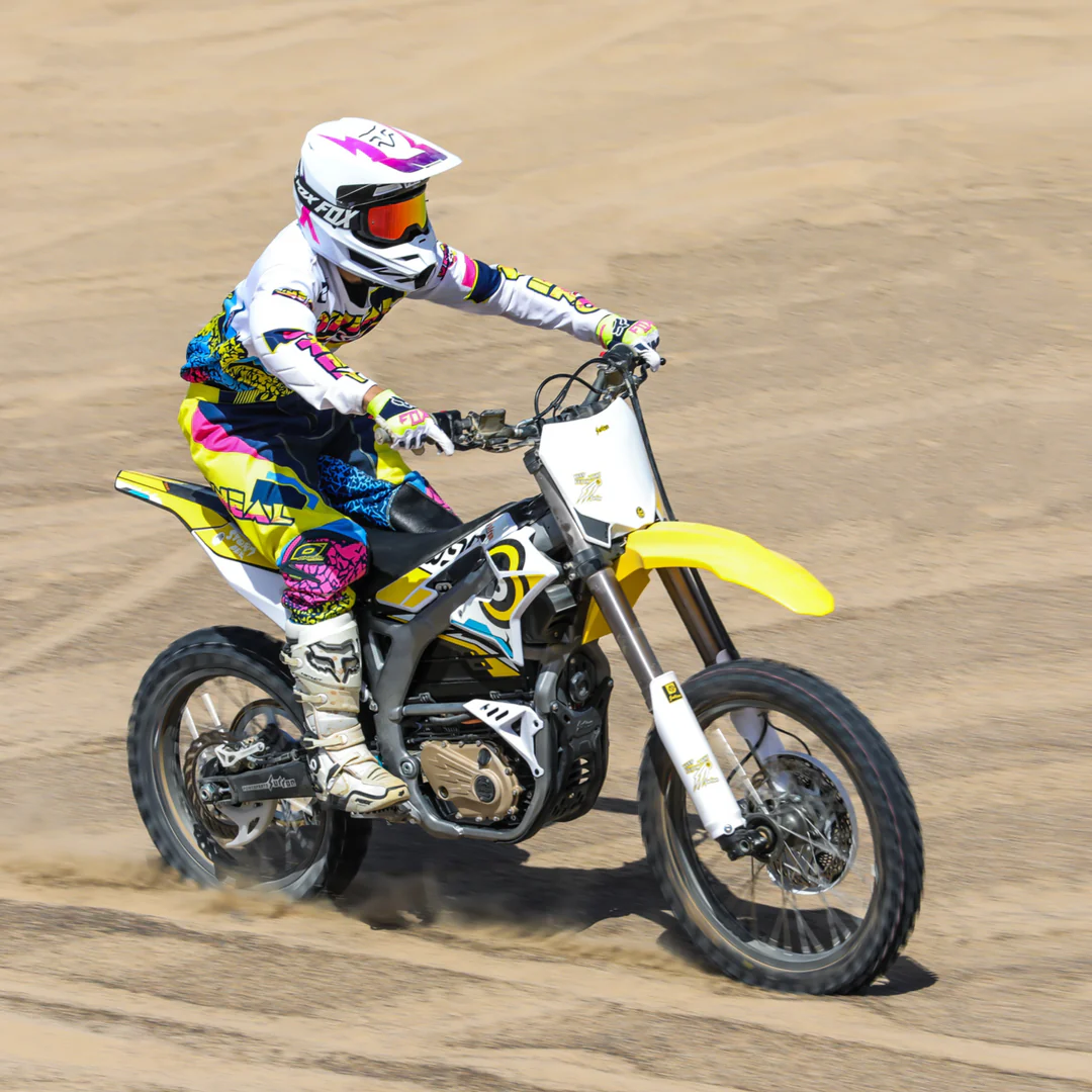 a person riding a surron storm bee mx electric dirt bike